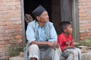 Nepali man and boy sitting on village steps