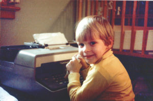 Steven Laman as a boy using typewriter
