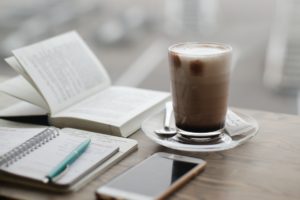 coffee cup phone and journal on table