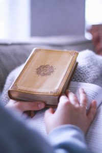 Woman hands sitting with Bible doing devotions