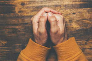 top view of male crossed hands in prayer