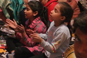 Two young Indian girls worshipping in church