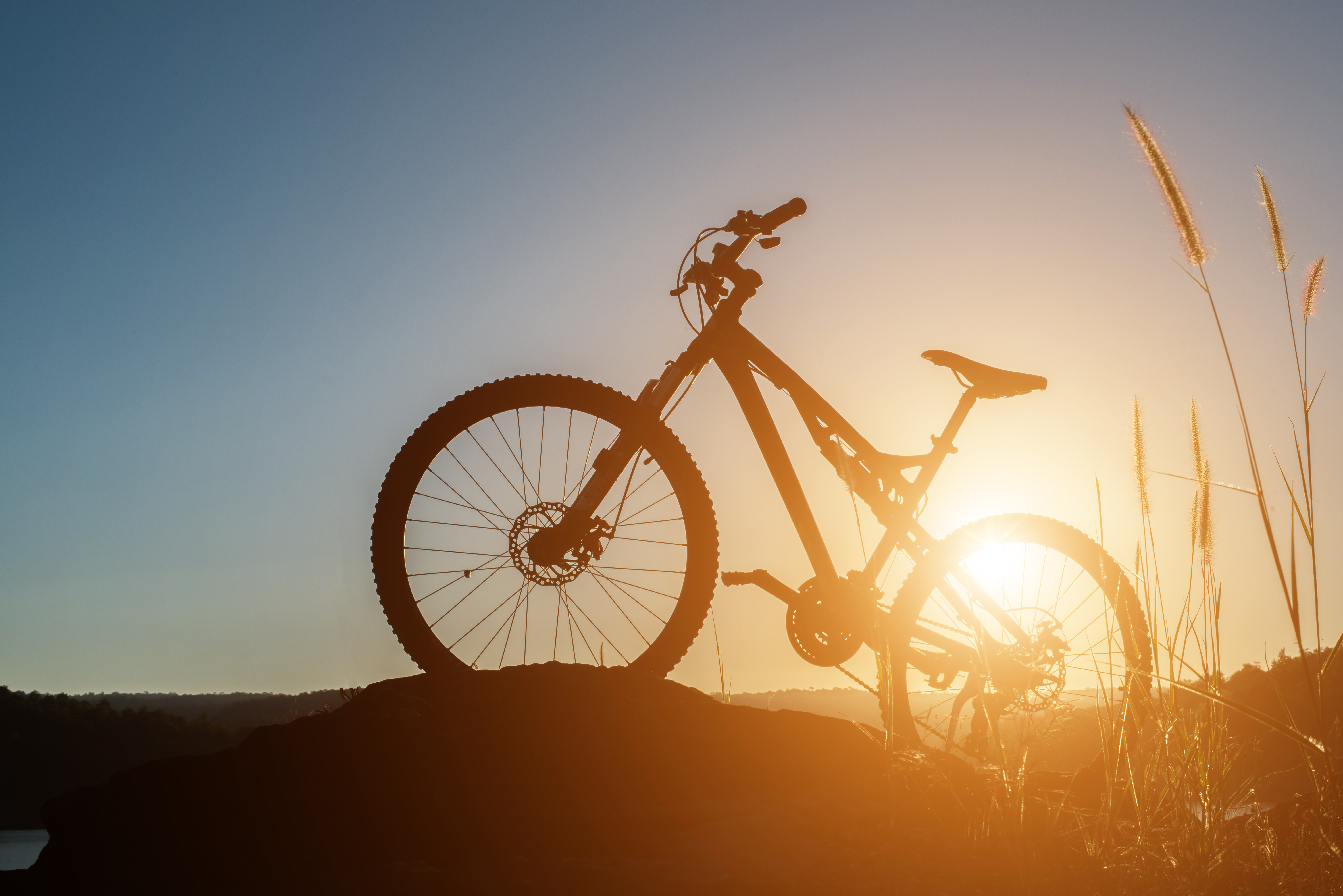 Silhouette Mountain biking on the rock at sky sunset