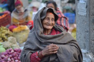 smiling indian woman with headcovering at outdoor market