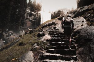 man hiking up stone steps mountain