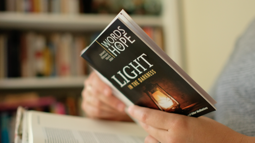 woman holding open devotional booklet