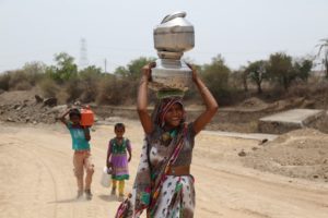 indian woman and children carrying pots on head