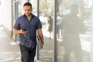 man walking outside looking at phone