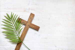 Cross and palm on wooden white background easter sign symbol concept