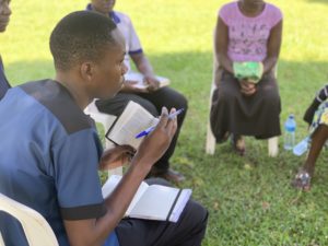 ugandan man reading bible outside