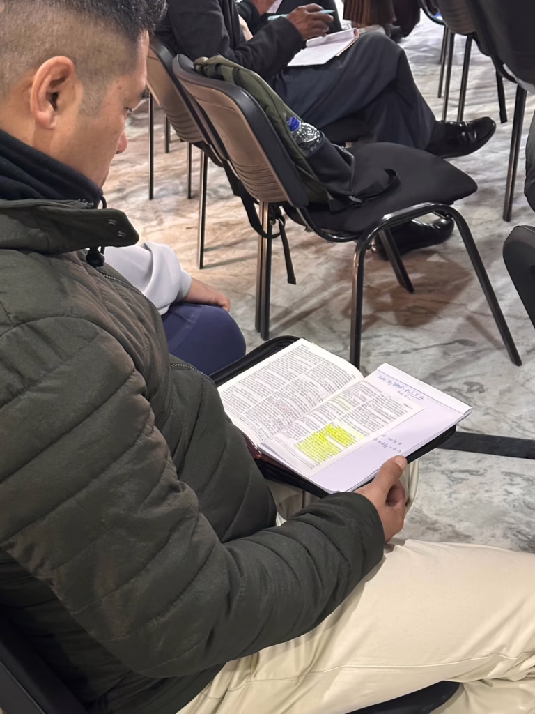 man holding bible in classroom