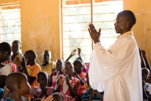 man praying in uganda classroom