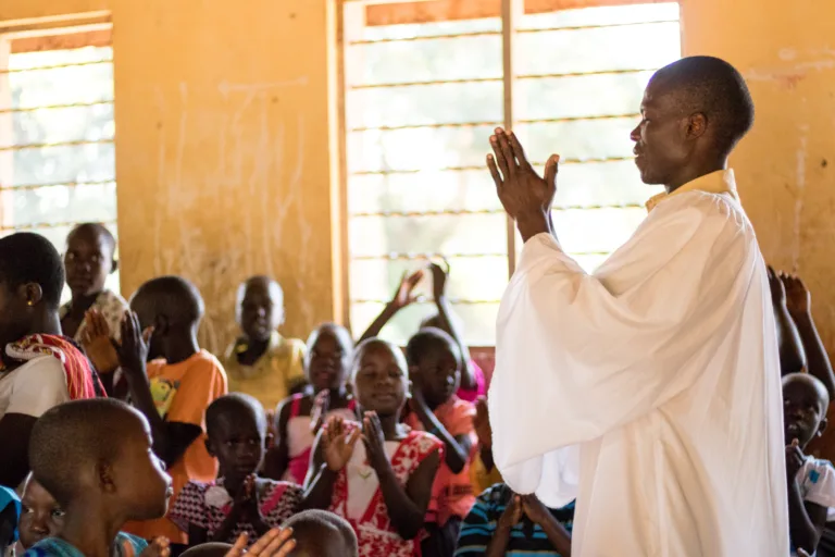 man praying in uganda classroom